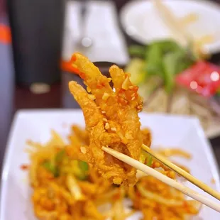 a plate of fried food with chopsticks