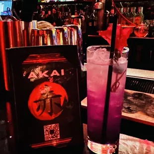 a purple drink and a menu at a bar