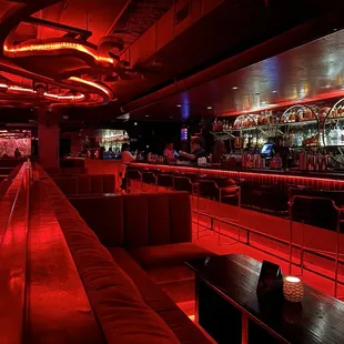 a dimly lit bar with red lighting