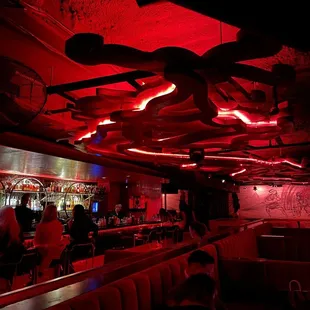 the interior of a restaurant with red lighting