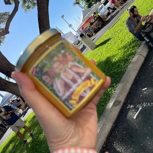 a hand holding a jar of honey