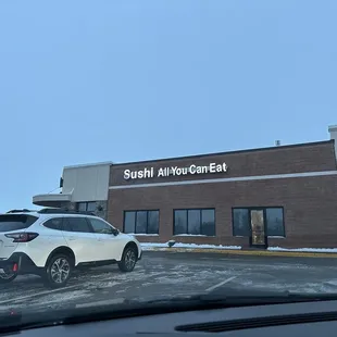 a car parked in front of a sushi auto center