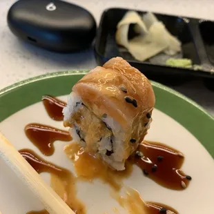 a plate of sushi with chopsticks