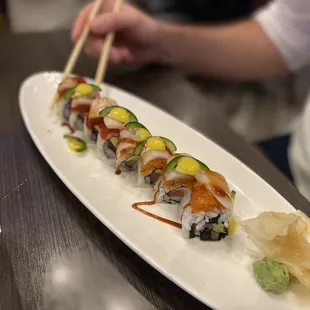 a plate of sushi with chopsticks