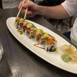 a plate of sushi with chopsticks