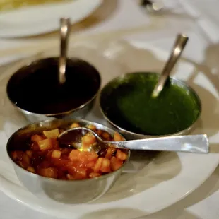 a plate of food with sauces and dips