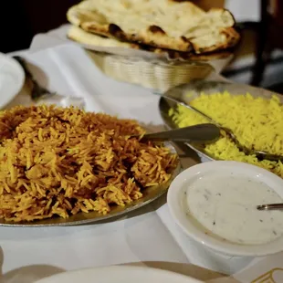 a plate of rice with a side of naan bread