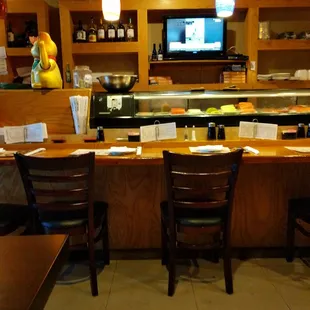 a restaurant counter with a tv in the background