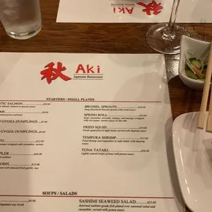 a menu with a glass of wine and chopsticks