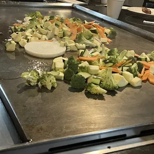 The veggies cooking on the flat top