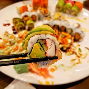 a plate of sushi with chopsticks