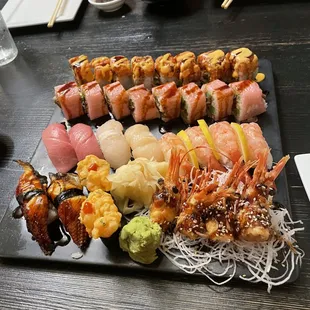 a platter of sushi on a black plate