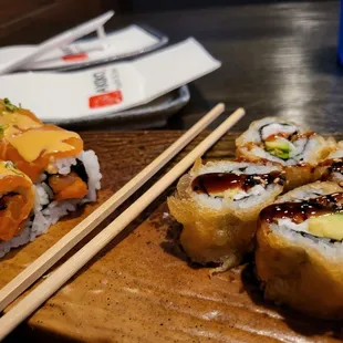 a plate of sushi and chopsticks