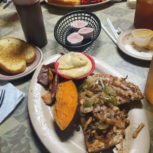12oz Grilled chicken breast with baked sweet potato, banana pudding, and garlic toast.