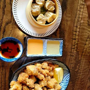 a bowl of dumplings and a bowl of dipping sauce