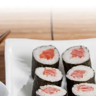 a plate of sushi rolls and a bowl of sauce