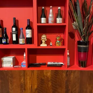 a shelf with bottles of wine and a remote control