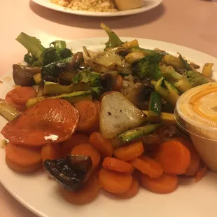 a plate of carrots, broccoli, and other vegetables