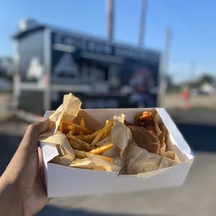 a person holding a box of food