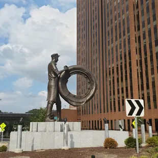 a statue of a man holding a tire