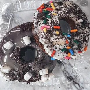 two chocolate donuts with sprinkles