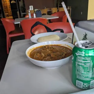 a bowl of soup and a can of soda