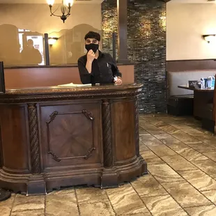 a man standing at the front desk of a restaurant