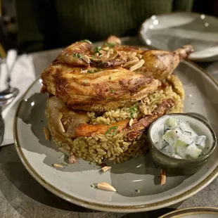 Maklouba - slowly cooked chicken, carrots, potatoes, cauliflower, eggplant, and rice, topped with parsley and slivered almonds