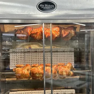 a display case with roasting chickens