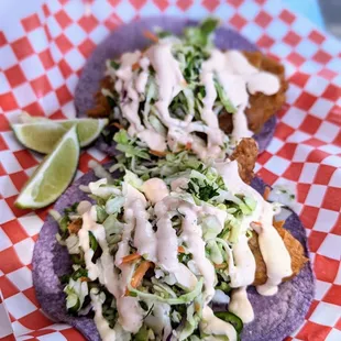 two fish tacos on a checkered plate