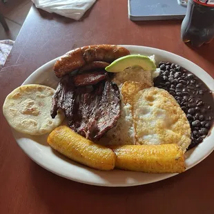 Bandeja Paisa plate..... fried plantain, beef skirt steak, egg, sausage, avocado and more!
