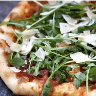 a pizza topped with arugula and cheese