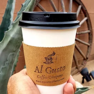 a hand holding a cup of coffee