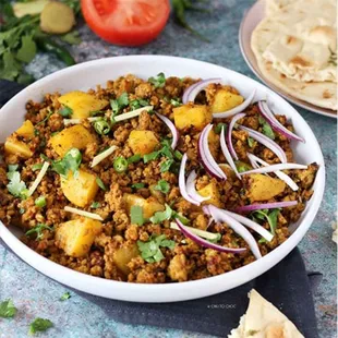 Aloo Keema Fusion: Succulent minced meat meets tender potatoes in a harmonious blend of spices, creating a flavorful dish that&apos;s both hearty