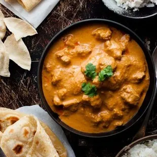 Butter Chicken with Rice: Succulent chicken pieces enveloped in a rich, creamy tomato-based curry, served alongside fragrant basmati rice.