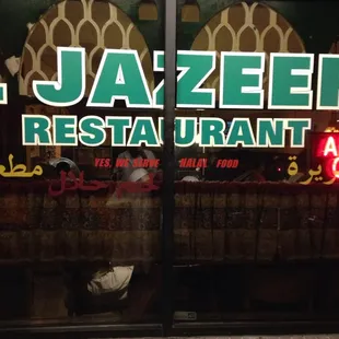 a woman sitting on a bench in front of a restaurant