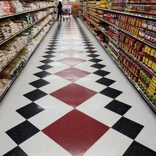 a grocery store aisle with a checkered floor