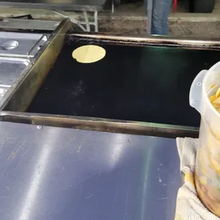 Freshly made tortillas (see her rolling them out)