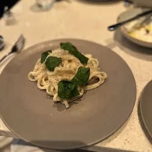 Table side fettuccini, one portion, topped with fresh basil