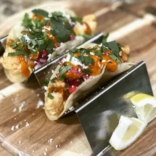 two tacos on a cutting board