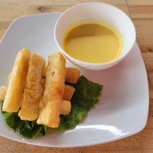 Yuca a la Huancaina - Fried yuca covered with a creamy yellow Peruvian pepper sauce.