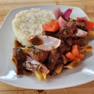 Lomo Saltado - Sauteed beef, red onions, tomatoes, french fries served with white rice.
