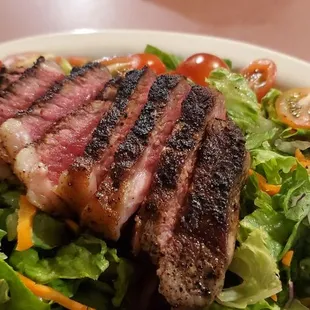 a steak on a bed of lettuce