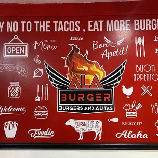 a red wall with a sign that says say no to the tacos eat more burgers