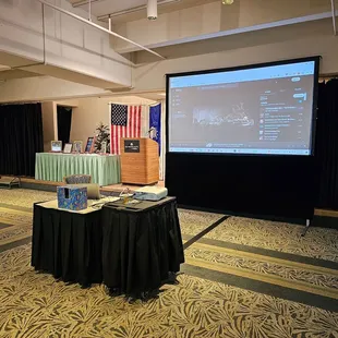 Good audio-visual equipment with stage, lecturn, and covered tables