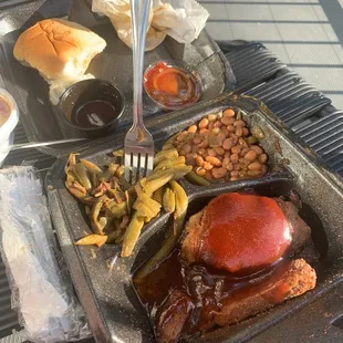 Brisket with baked beans. Green beans and a roll.