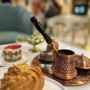 a cup of coffee and a pastry on a tray