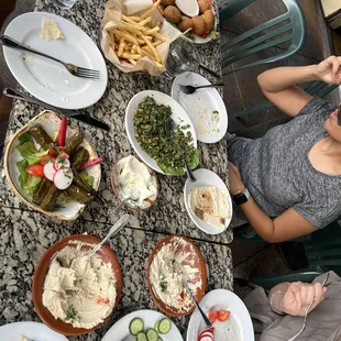 a woman sitting at a table full of food