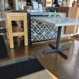 Counter with sanitized/dirty pens and sanitizer. Table helps with social distancing at counter