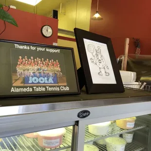 Bagel mascot and their table tennis team on top of t a fridge of house made cream cheeses, so fun